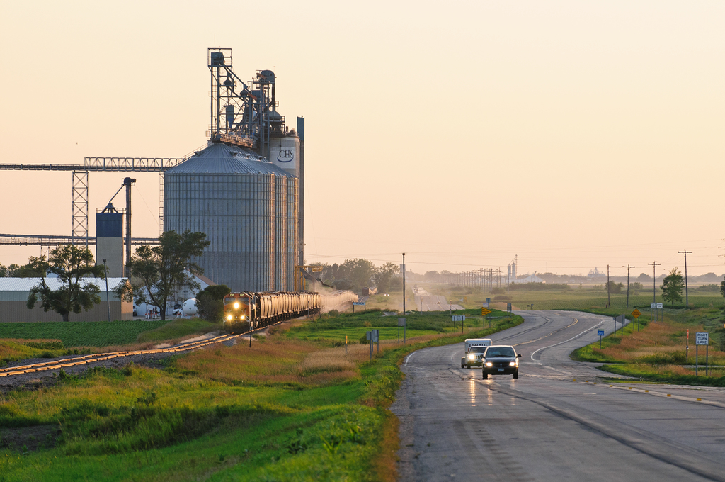 Train running parallel to a road in rural Minnesota