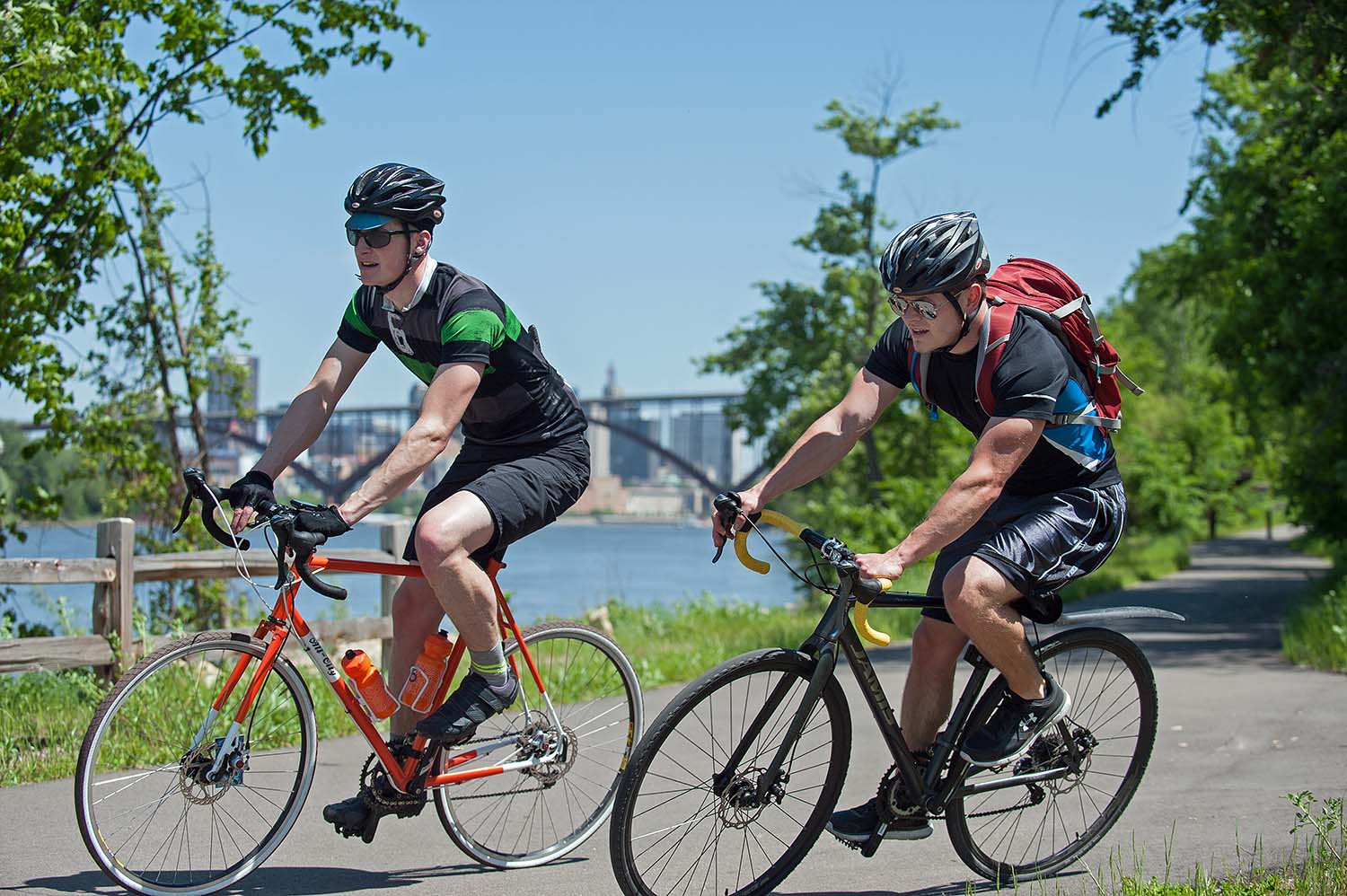 Bicyclists ride on bike trail next to lake in Twin Cities 